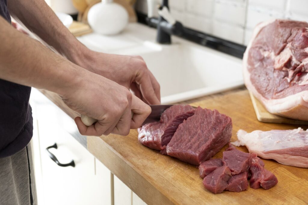 Persona cortando tiernos filetes de ternera de Carnicerías Rubio en Nules, para una comida casera