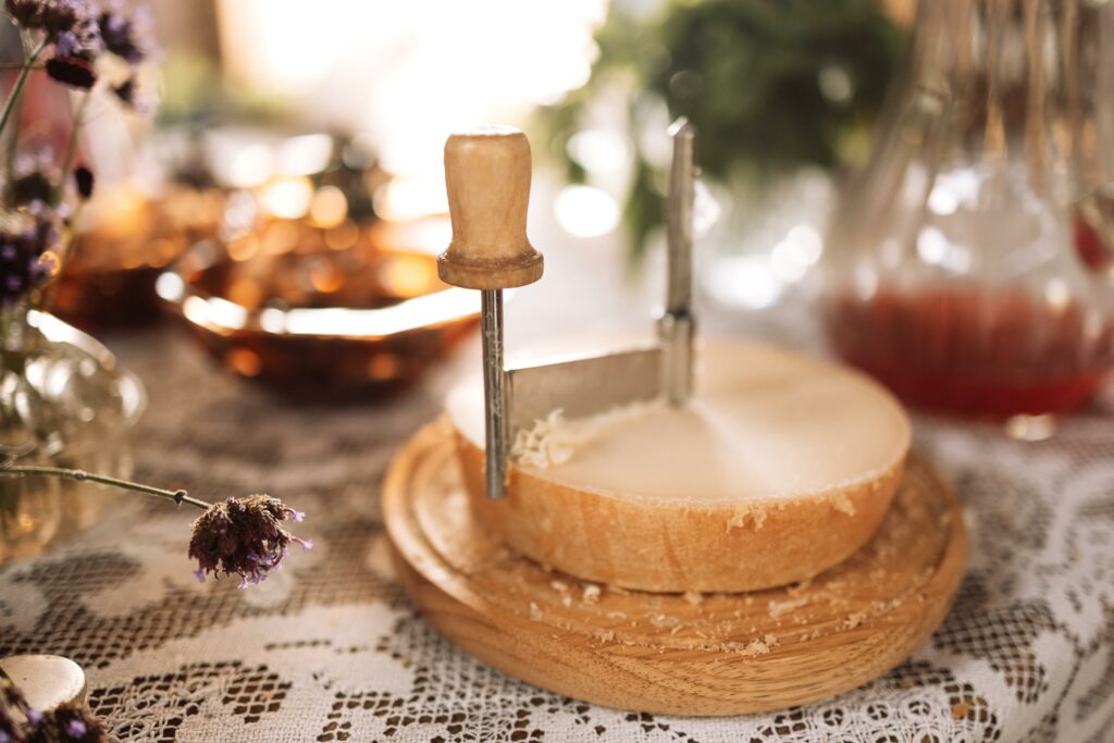 Queso Tête de Moine siendo raspado con una girolle para crear delicadas flores de queso en Carnicería Rubio, Nules