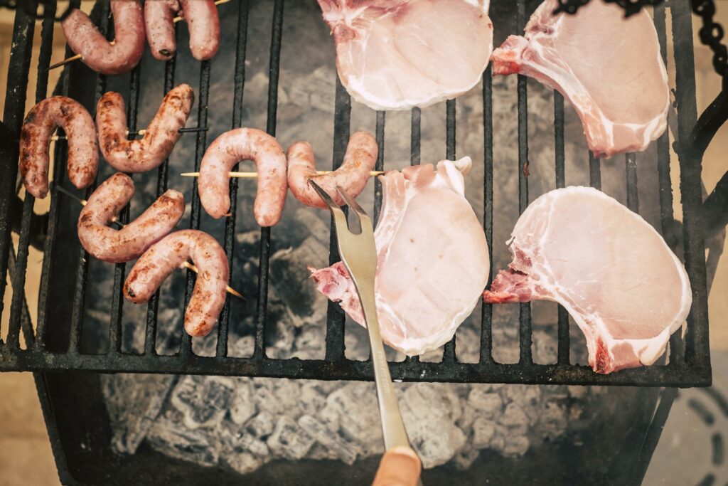 Parrillada con productos frescos de Carnicería Rubio en Nules: salchichas y chuletas de cerdo a la brasa, perfectas para tus barbacoas
