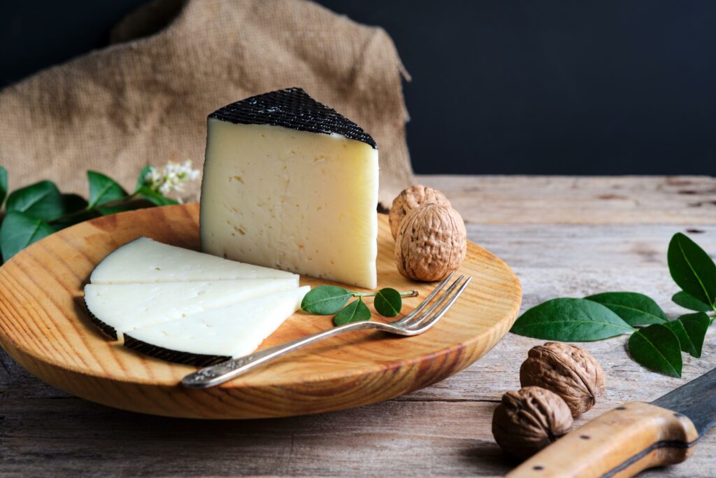 Queso de oveja curado con nueces en un plato de madera Encuéntralo en Carnicería Rubio en Nules queso gourmet