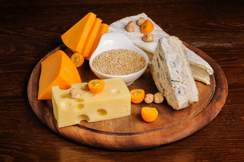 Cuña de queso curado en primer plano sobre un mostrador con más variedades de quesos en Carnicería Rubio, Nules